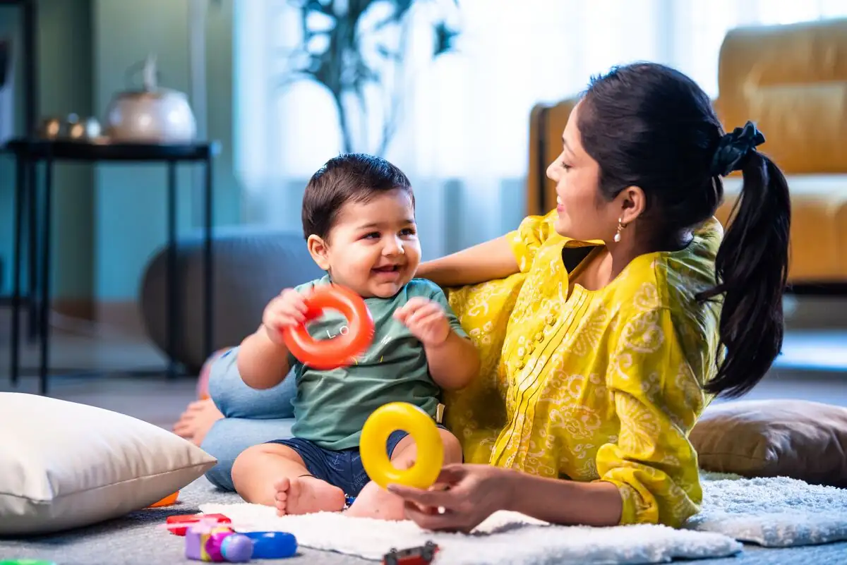 Brain development activities for babies - a mother and her baby playing with rings on the floor at home