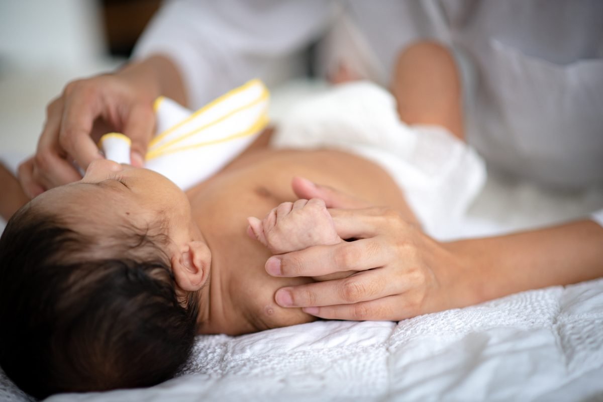 Preterm baby development milestones - a parent gently holding a newborn baby's tiny fingers